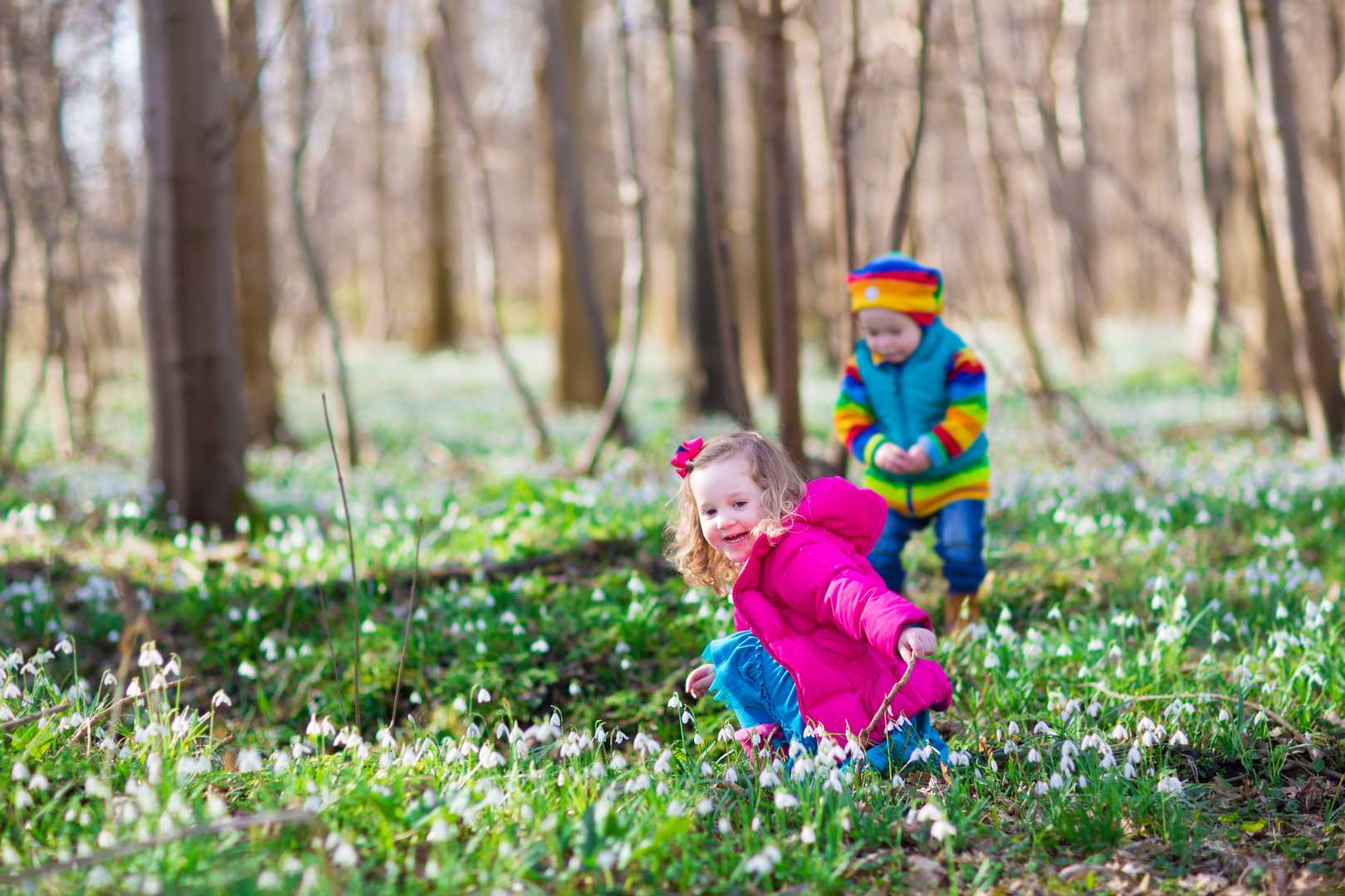 zwei Kinder spielen im Wald in Schneegl&ouml;ckchen