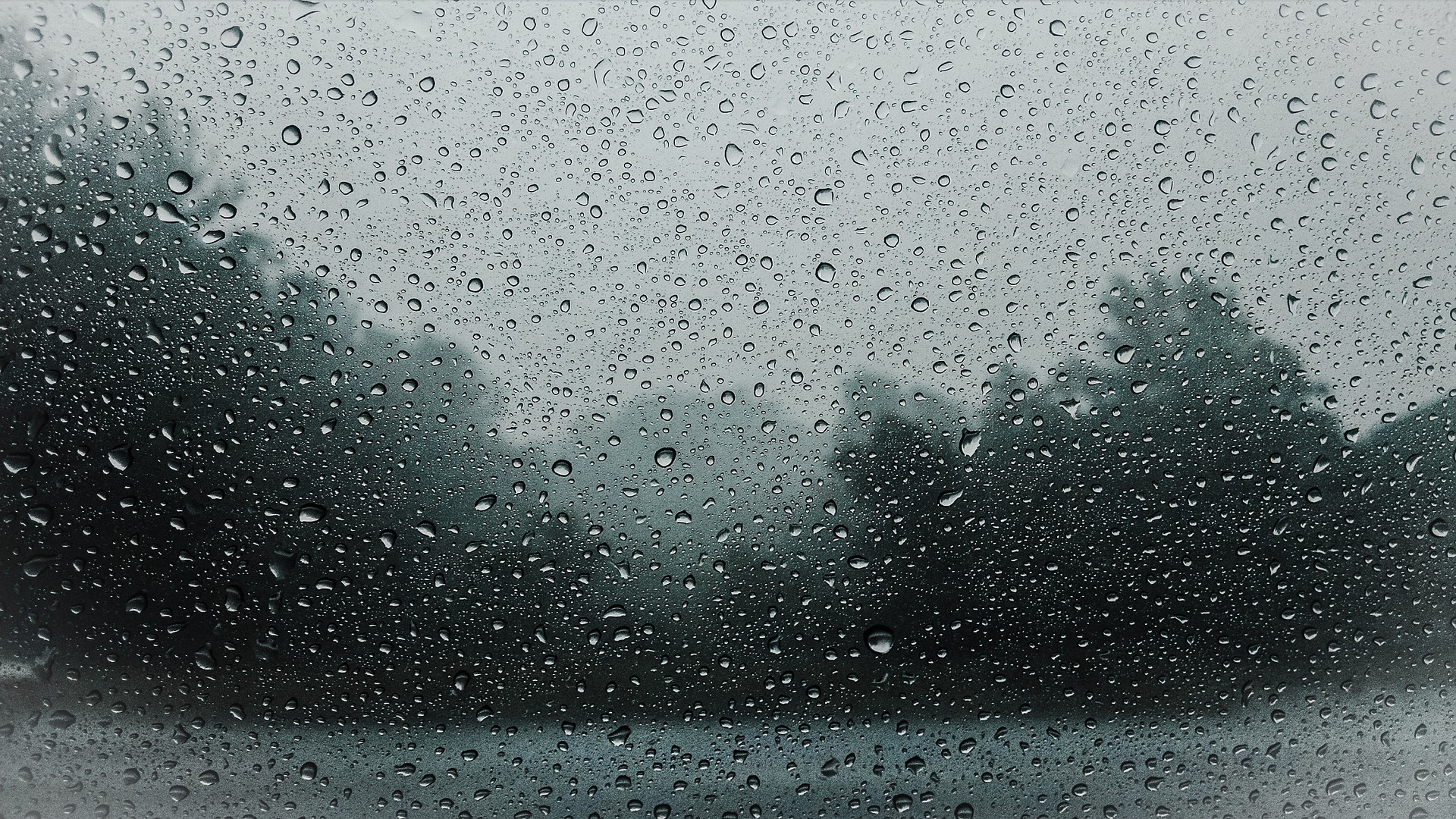 Landschaft hinte einer Glasscheibe bei Regen