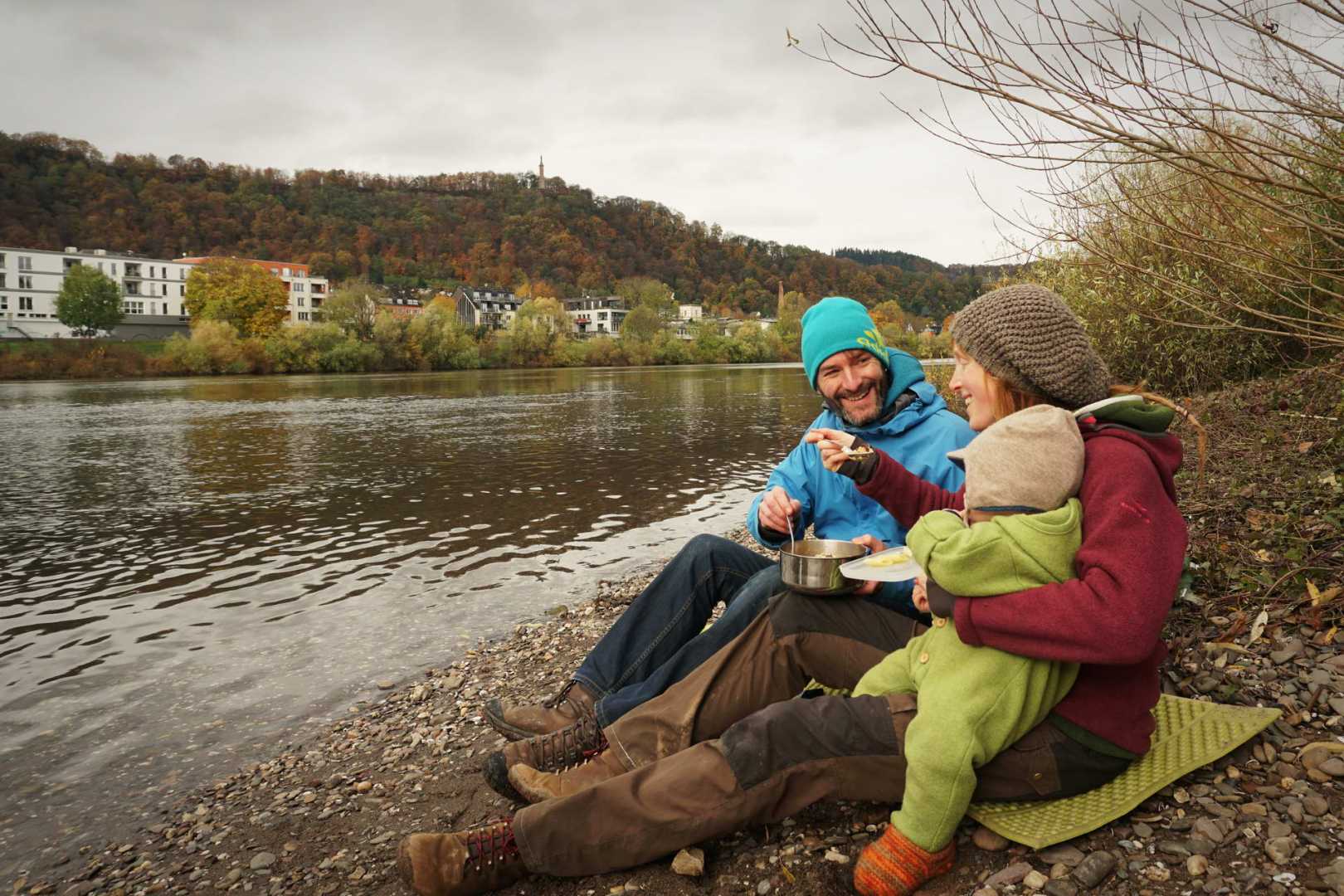 Familie am Fluss isst Couscous