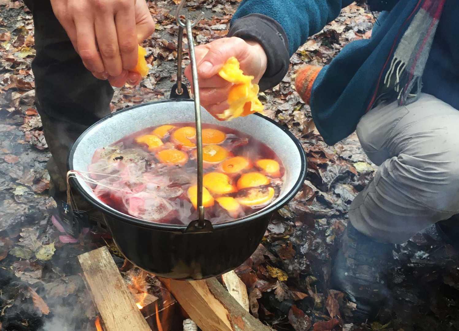Orangen auspressen in den Winter Punsch &uuml;ber dem Lagerfeuer